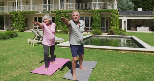 Senior couple enjoying yoga session in sunny backyard garden. Ideal for promoting active aging, healthy lifestyle, and fitness among elderly population. Great for health and wellness advertisements, yoga classes for seniors, and articles on senior fitness.