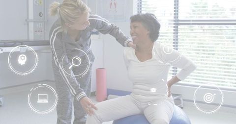 Therapist guiding patient on exercise ball during rehabilitation session with hud icons