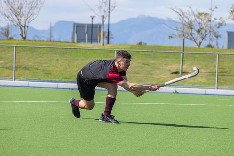 Athlete During Intense Field Hockey Play on Green Turf