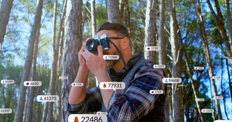Mature photographer in forest surrounded by digital social notifications