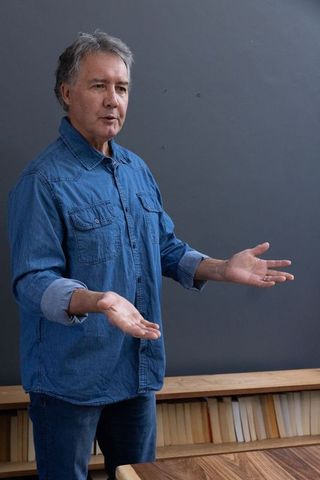 Mature Man Wearing Jeans Shirt Explaining Concepts
