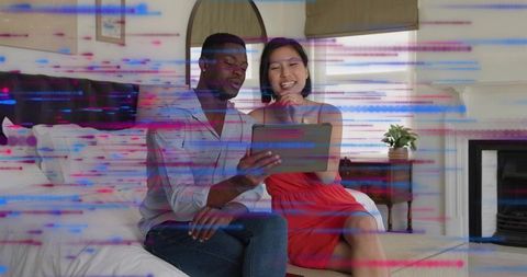 Couple sharing tablet on cozy modern bedroom bed with colorful digital glitch overlay