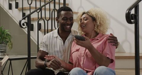 Couple Enjoy Bonding on Stairs with Gift Box and Laughter