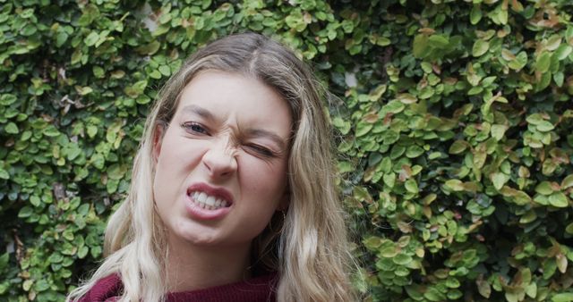 Woman Making Silly Expression Against Green Foliage Background - Download Free Stock Images Pikwizard.com