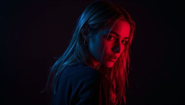 Cinematic portrait of female model in red and blue gel lighting with dramatic rimlight
