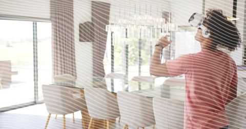 Young man using vr headset in modern dining room enjoying immersive home technology