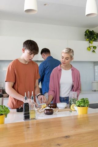 African american family preparing fresh lemon herb meal on modern kitchen island