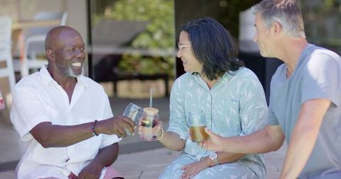 Diverse friends enjoying refreshing drinks in relaxing outdoors