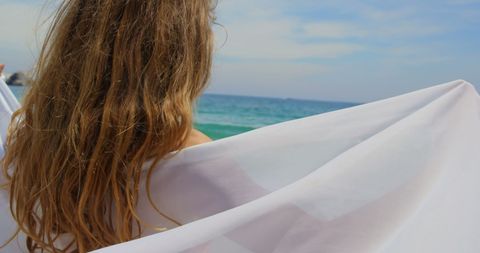 Woman with Flowing Hair Enjoying Serene Beach View