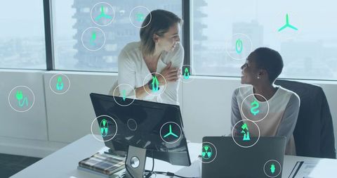 Collaborating on sustainable energy strategy in modern office with floating green icons