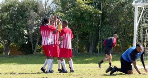 Soccer Team Celebrating Victory on Grass Field