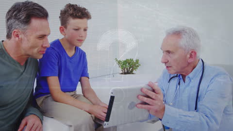 Senior Doctor Advising Father and Son with Digital Tablet