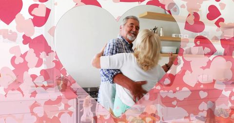 Elderly Caucasian Couple Dancing with Heart Design in Kitchen