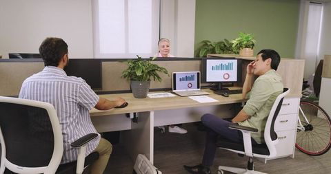 Diverse Team Analyzing Charts at Open-Plan Office Workspace