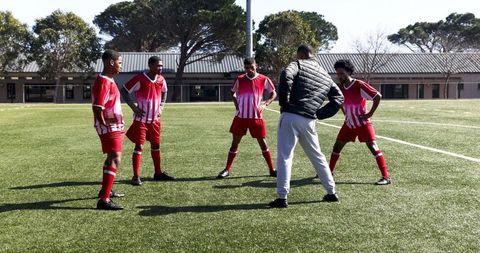 Soccer Coach Guiding Team During Field Practice Session