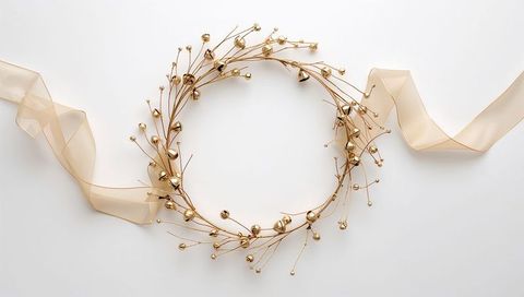 Elegant gold wire holiday wreath featuring bell accents and sheer beige ribbon