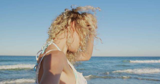 Carefree Woman with Curly Hair on Beach Enjoying Ocean Breeze - Download Free Stock Images Pikwizard.com