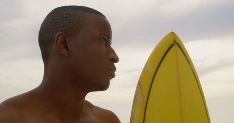 African American Surfer with Yellow Surfboard on Beach