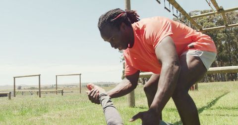 Athlete Helping Teammate on Obstacle Course Outdoors
