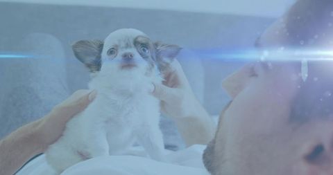 Relaxing man cradling tiny puppy in cozy home setting