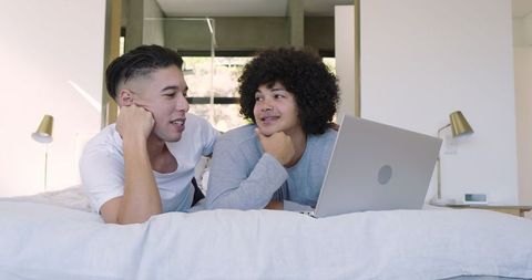Relaxed Couple Enjoying Quality Time with Laptop in Modern Bedroom