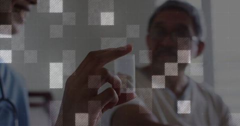 Doctor in Clinic Showing Capsule Through Digital Pixelate Grid