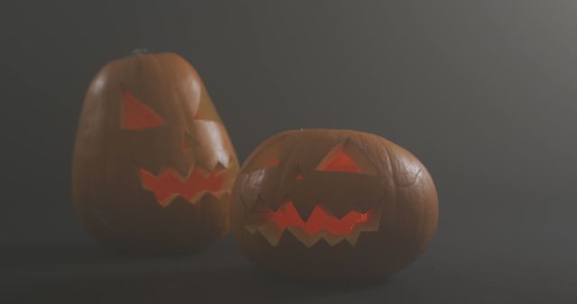 This photo depicts two glowing Jack-o'-lanterns in a dark setting, ideal for capturing the eerie essence of Halloween. They are carved with sharp, menacing expressions, making them perfect for creating a spooky atmosphere. This photo can be used for Halloween-themed invitations, festive website banners, or social media posts celebrating the holiday.