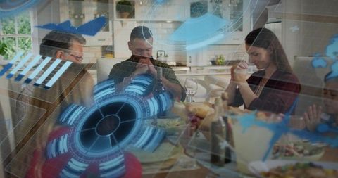 Family praying around dinner table at home with futuristic holographic hud overlay
