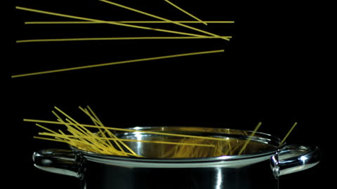 Spaghetti Falling Into Stainless Steel Pot in Slow Motion