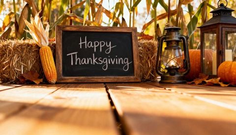 Rustic Thanksgiving Chalkboard with Lantern, Pumpkins and Corn on Wooden Porch