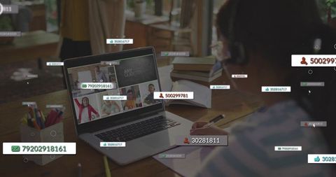 Remote learning student taking notes during virtual classroom on laptop with headphones