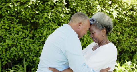 Senior Couple Embracing In Lush Garden Setting