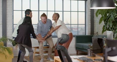 Celebrating Success Diverse Team Joining Hands in Office