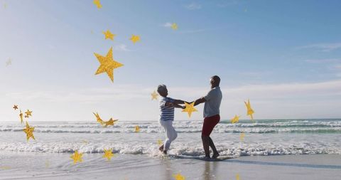 Senior couple dancing and spinning on sunlit shoreline with golden star confetti overlay