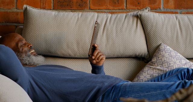 Senior Man Relaxing on Sofa Reading Tablet - Download Free Stock Images Pikwizard.com