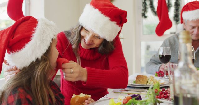 Family Celebrating Christmas with Santa Hats and Festive Meal - Download Free Stock Images Pikwizard.com