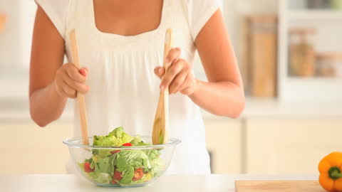 Women Creating Fresh Salad with Wooden Utensils