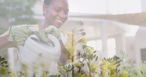 Smiling African American Woman Watering Vibrant Garden Flowers