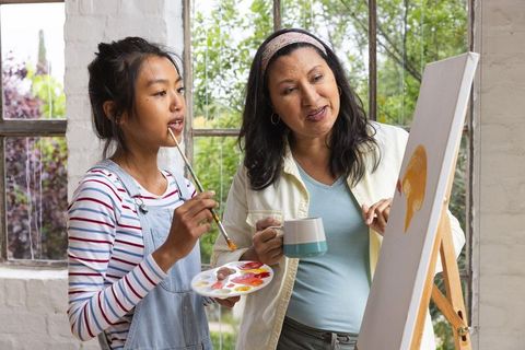 Young Artist and Mentor Painting Together in Art Studio