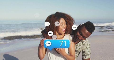Loving Couple Embracing on Sandy Beach with Social Media Interaction