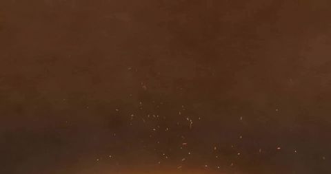 Rising embers and sparks drifting through smoky night sky over campfire glow, warm atmosphere