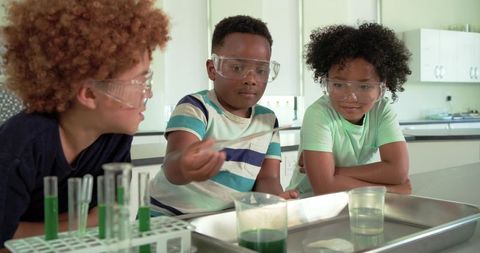 African american boys conducting science experiment in school lab wearing safety goggles