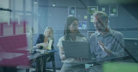 Colleagues Discussing Data Insights with Laptop and Digital Graphics