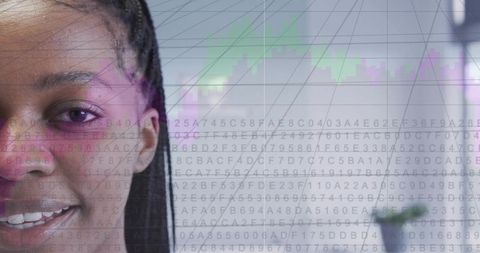 Smiling woman coding with data visualization overlay in modern office workspace