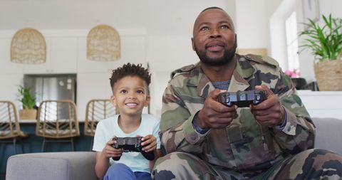 Father in Military Uniform Playing Video Games with Son at Home