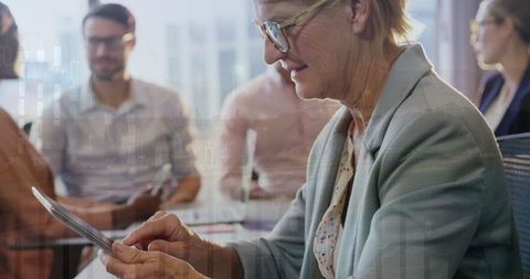 Senior Businesswoman Analyzing Financial Data on Digital Tablet