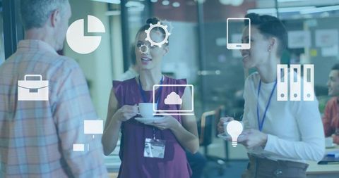 Professionals networking over coffee in open-plan office with digital tech icons overlay