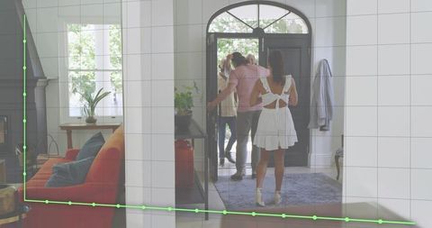 Woman Wearing White Dress Welcoming Family at Arched Front Door with Cozy Living Room