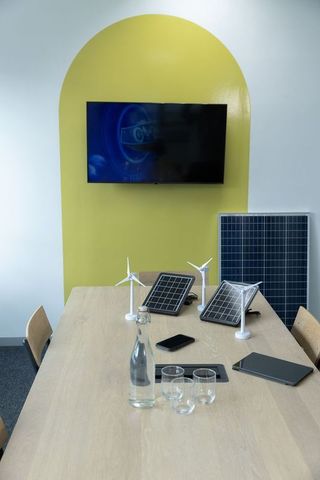 Conference table displaying solar panels and wind turbine models in modern boardroom