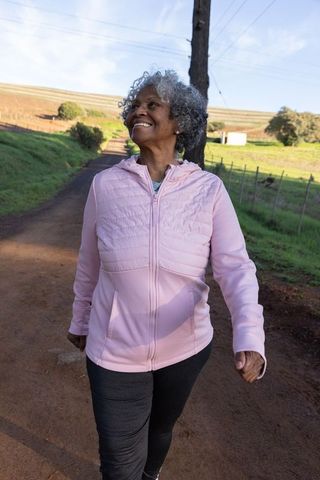 African American Senior Woman Enjoys Walk on Rural Pathway near Vineyard